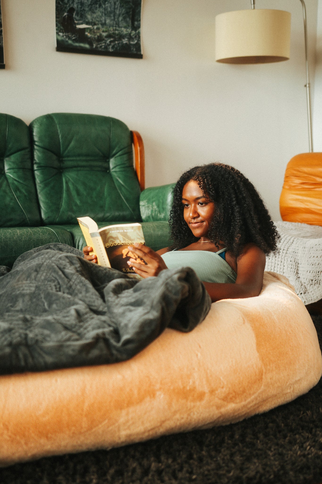 Woman reading book in the Plufl, the human dog bed