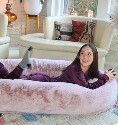 Cute girl posing happily in Plufl, the world's first dog bed for humans