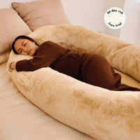 Girl sleeping comfortably in beige human dog bed