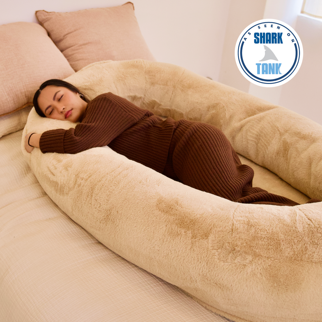 Person sleeping on a large plush pillow with 'As Seen on Shark Tank' logo.